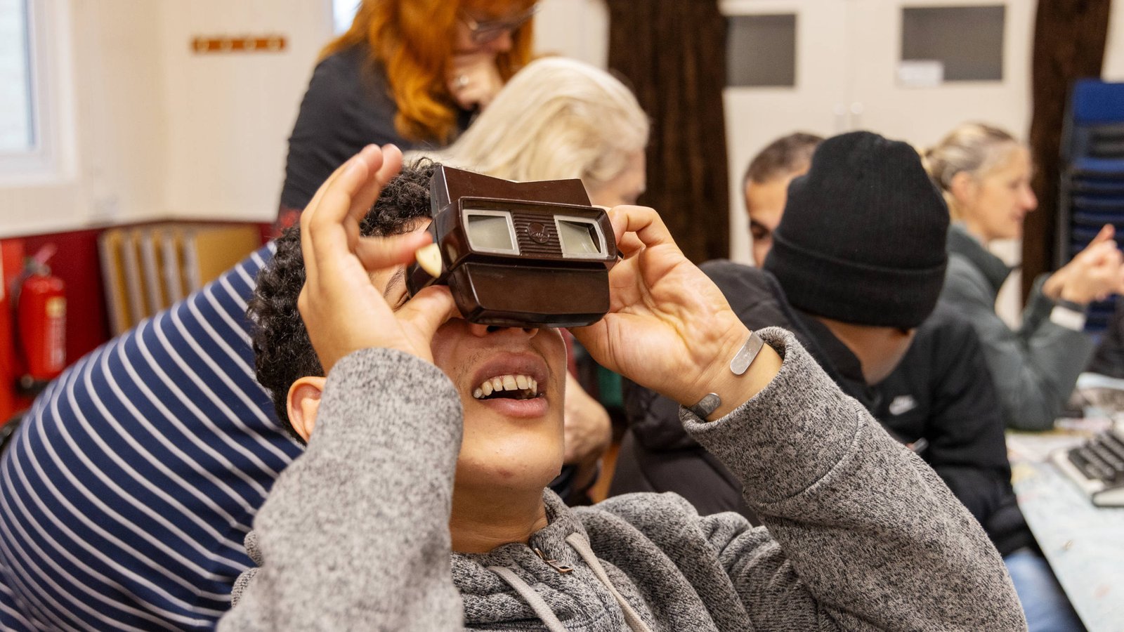 A young Middle Eastern man looks upwards into a stereoscope.